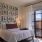 bedroom with large windows and a grid of wall art above the bed