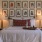 wide view of a bed with a grid of wall art and two lamps